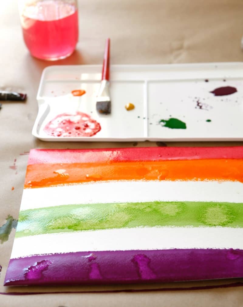 Watercolor painting stripes for a rainbow weaving art project for kids