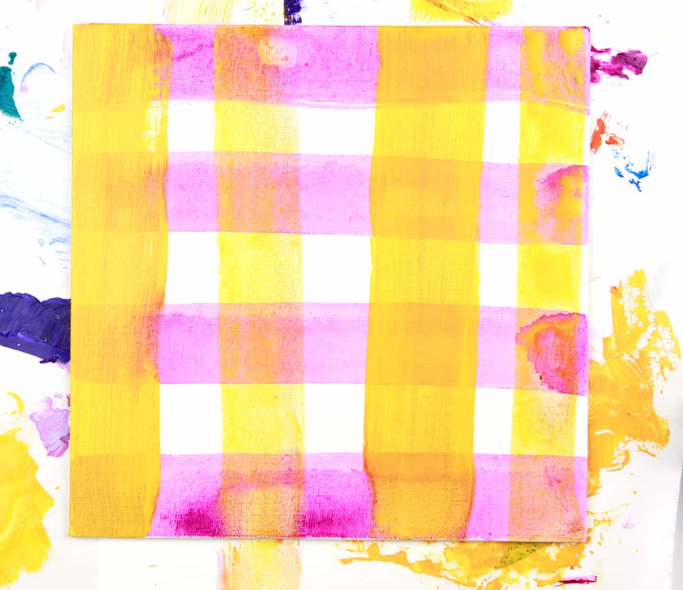 yellow and pink washes of acrylic paint in a plaid design