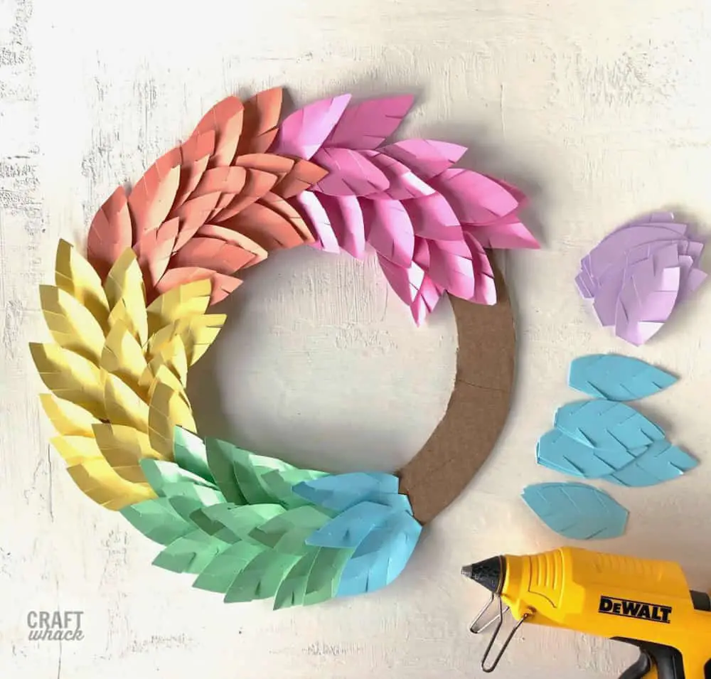 paper leaf wreath craft being made with different colors of paper leaves