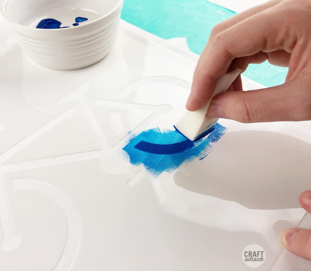 dabbing fabric paint in stencil with makeup sponge