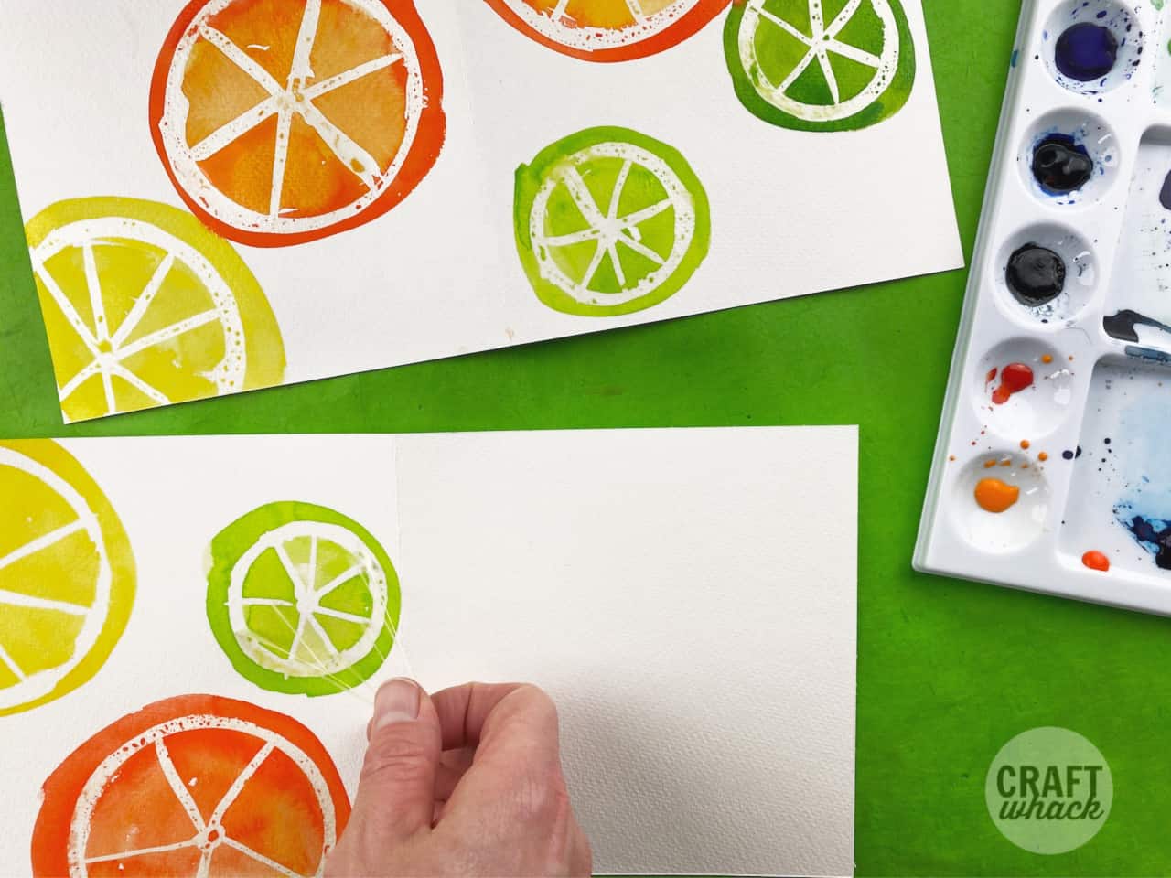 masking fluid being peeled from a fruit slice watercolor card