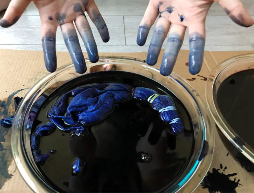 blue dyed fingers over a tie dye bowl