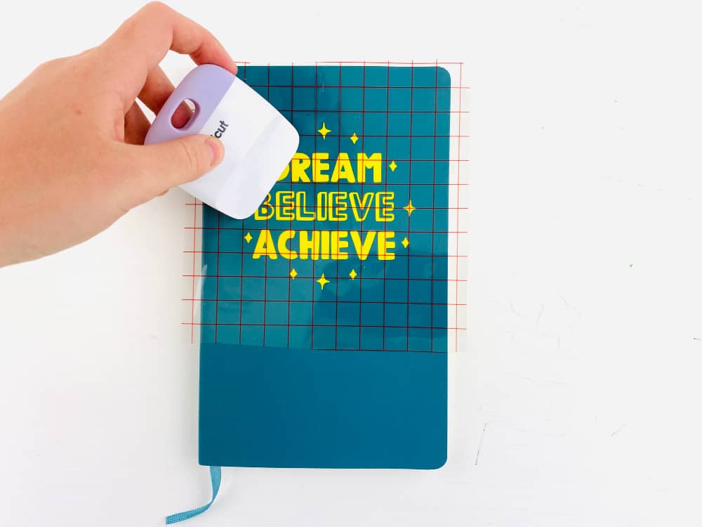 burnishing vinyl letters onto a notebook cover