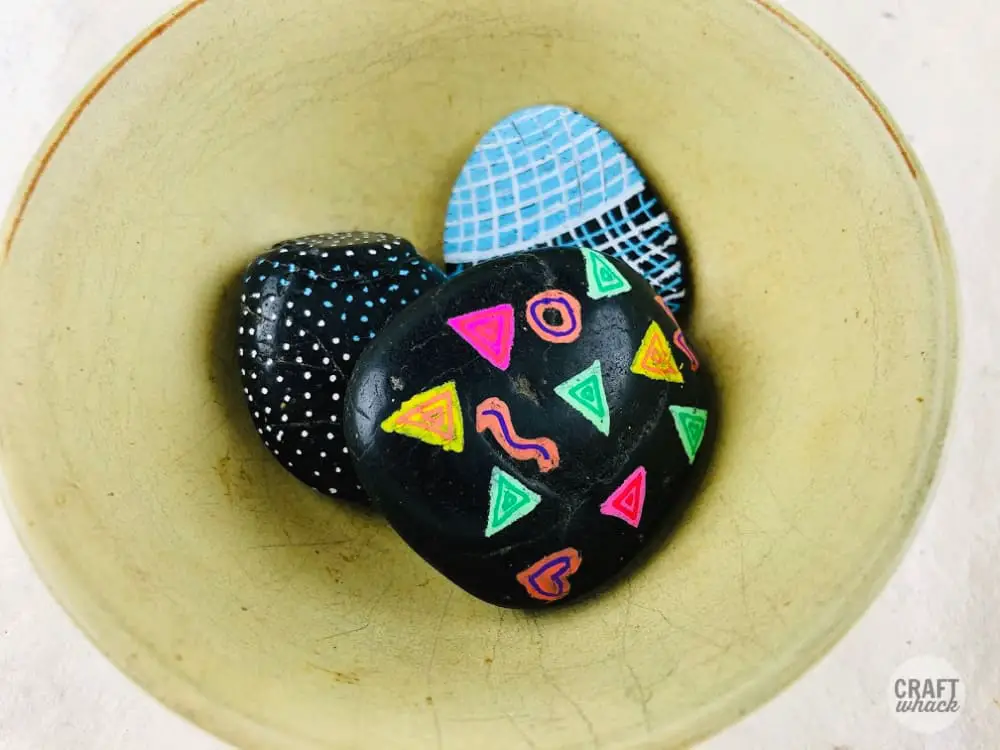 yellow bowl with black painted rocks